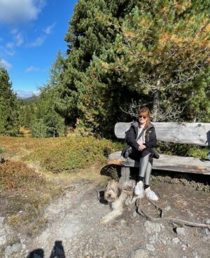Heino Hund und Dominique beim Wandern an einer Holzbank im Harz